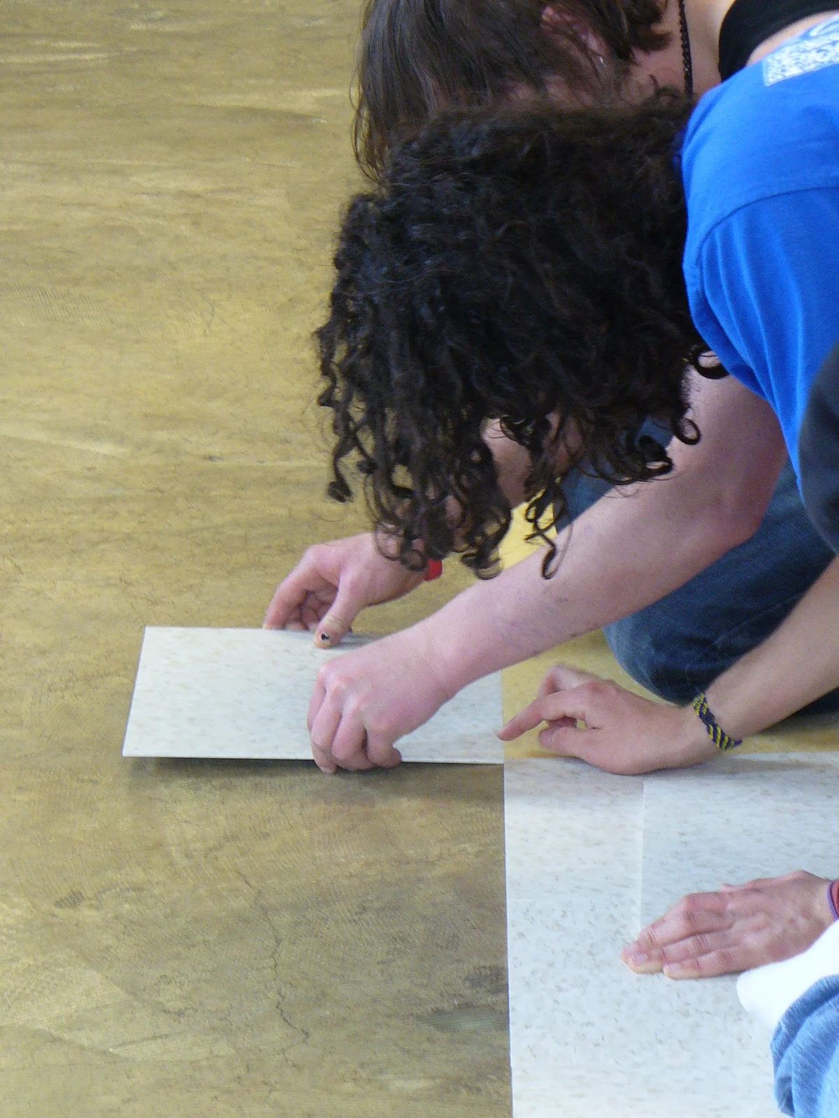 Pose de carreaux au sol sur un chantier intérieur.
